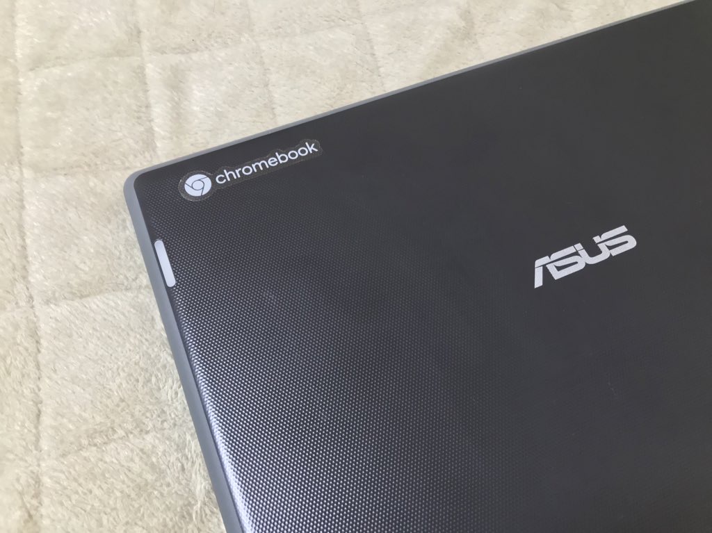 ASUS製のノートパソコンに、Chromebookのシールが貼られ、白いマットの上にある。